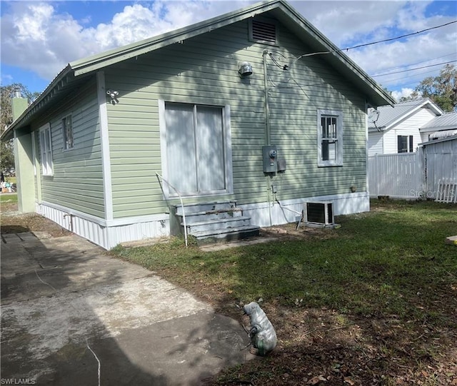 view of property exterior with a lawn and central air condition unit