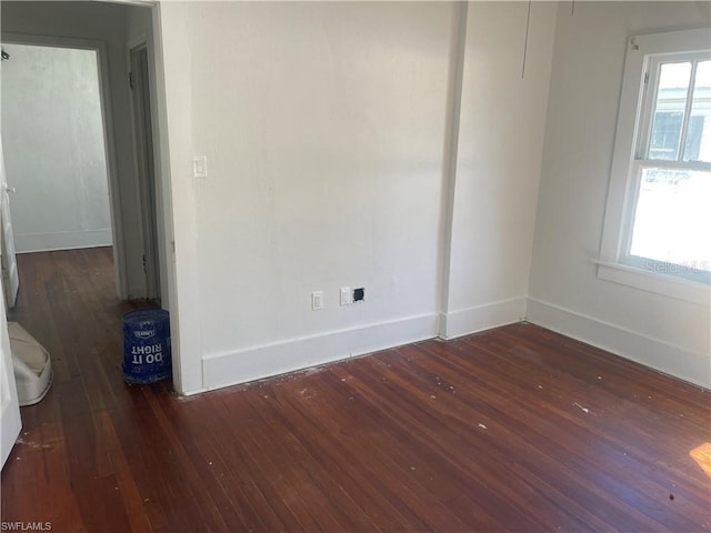 spare room with dark hardwood / wood-style floors and a wealth of natural light