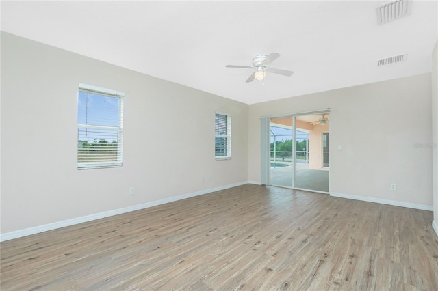 empty room with ceiling fan and light hardwood / wood-style floors