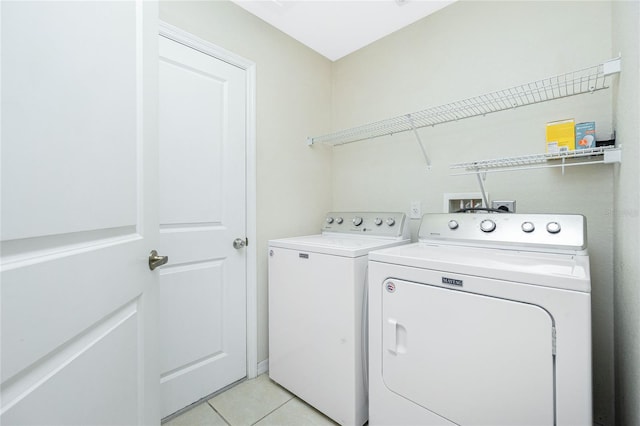 laundry room featuring washer and clothes dryer and light tile patterned floors