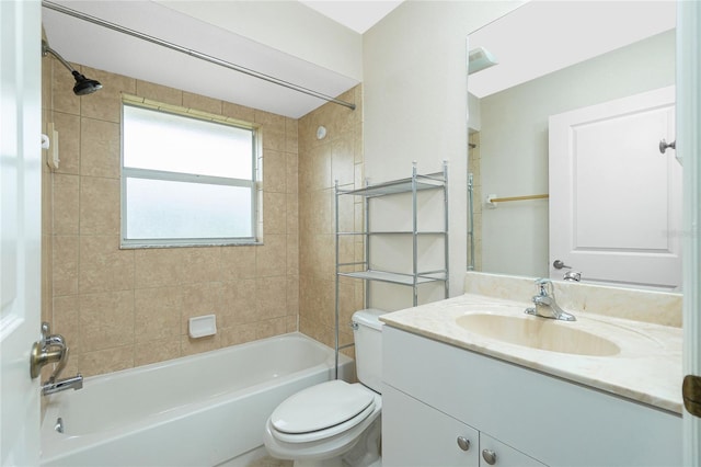 full bathroom featuring vanity, tiled shower / bath combo, and toilet