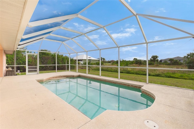 view of swimming pool featuring a lanai, a patio area, and a lawn