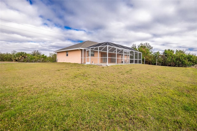 rear view of house featuring a yard and a lanai