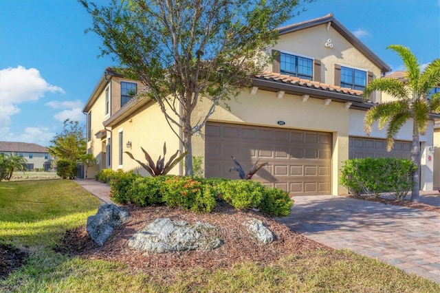 mediterranean / spanish-style home with a front yard and a garage