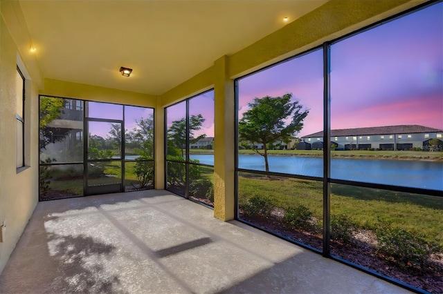 unfurnished sunroom featuring a water view