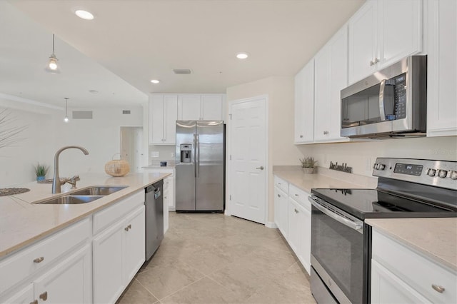 kitchen featuring light stone countertops, sink, hanging light fixtures, white cabinets, and appliances with stainless steel finishes