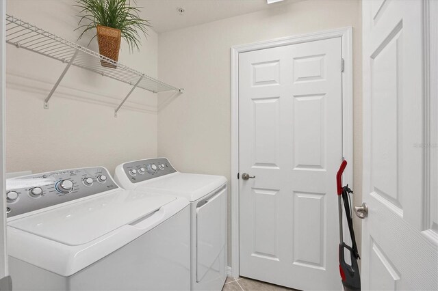 clothes washing area with light tile patterned flooring and independent washer and dryer