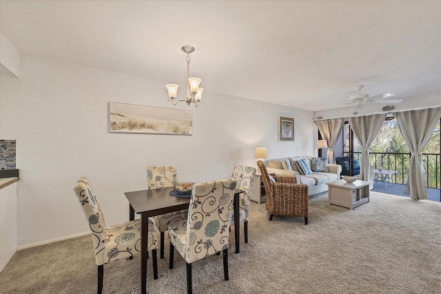 dining space featuring carpet floors and ceiling fan with notable chandelier