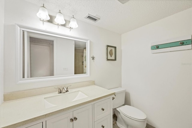 bathroom with vanity, a textured ceiling, toilet, and curtained shower