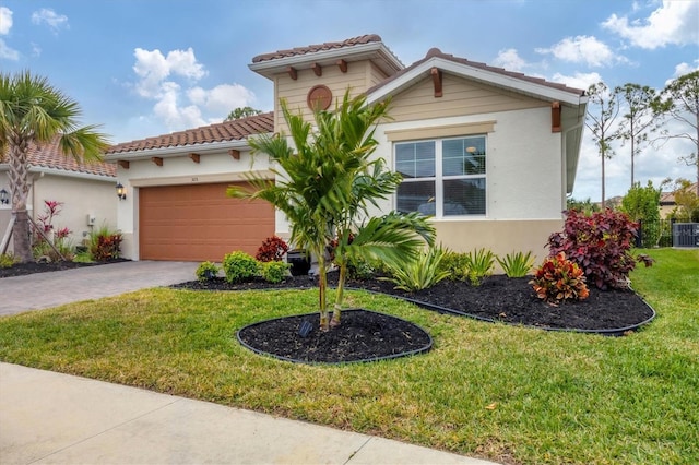 mediterranean / spanish home with a garage and a front lawn