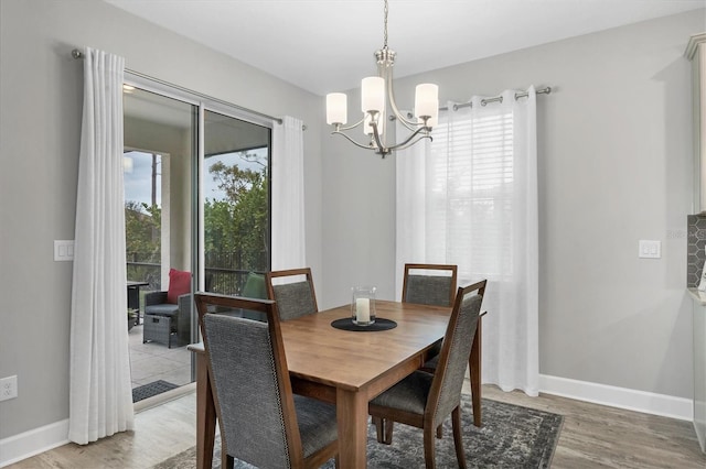 dining space with hardwood / wood-style floors and a chandelier