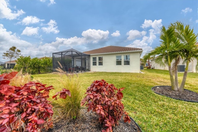 back of property featuring a lanai, central AC unit, and a lawn