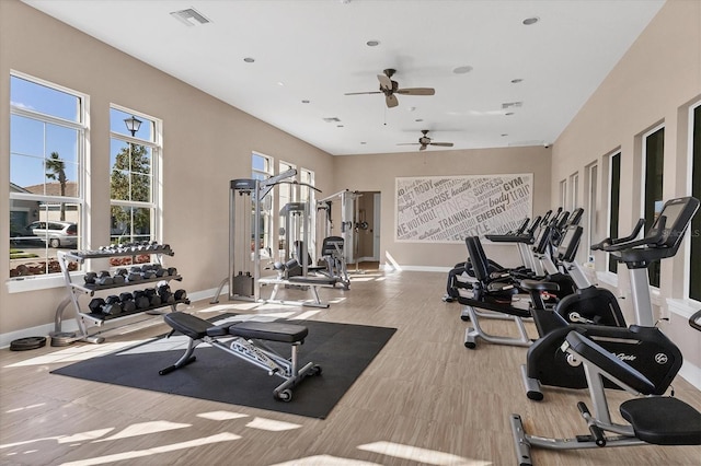 gym with ceiling fan and light hardwood / wood-style floors