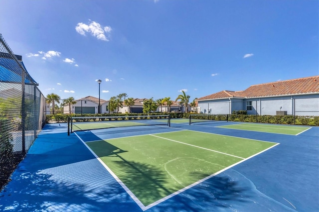 view of tennis court featuring basketball hoop