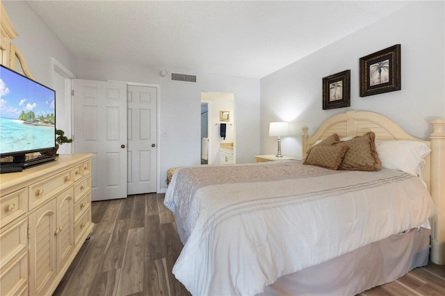 bedroom with dark wood-type flooring and a closet