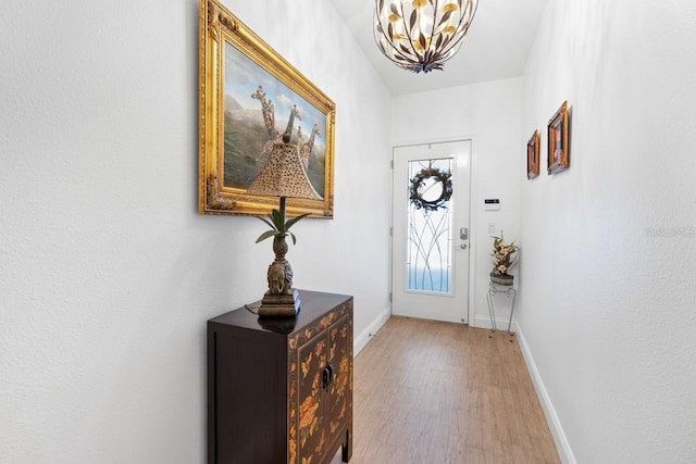 entryway featuring hardwood / wood-style floors and a notable chandelier