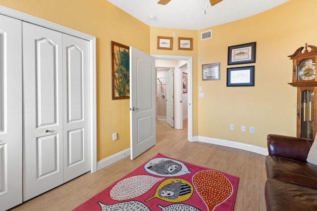 living area with ceiling fan and light hardwood / wood-style floors