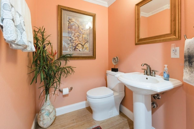 bathroom with hardwood / wood-style flooring, toilet, and ornamental molding