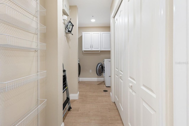 laundry room with cabinets, separate washer and dryer, and light hardwood / wood-style flooring