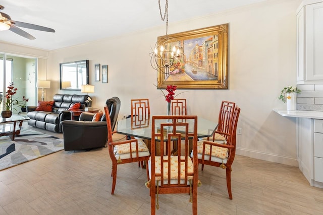 dining area with light hardwood / wood-style floors, ceiling fan with notable chandelier, and ornamental molding