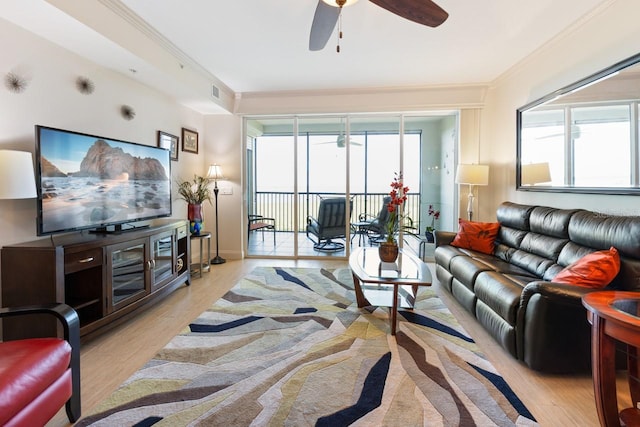 living room featuring crown molding, ceiling fan, a healthy amount of sunlight, and light wood-type flooring