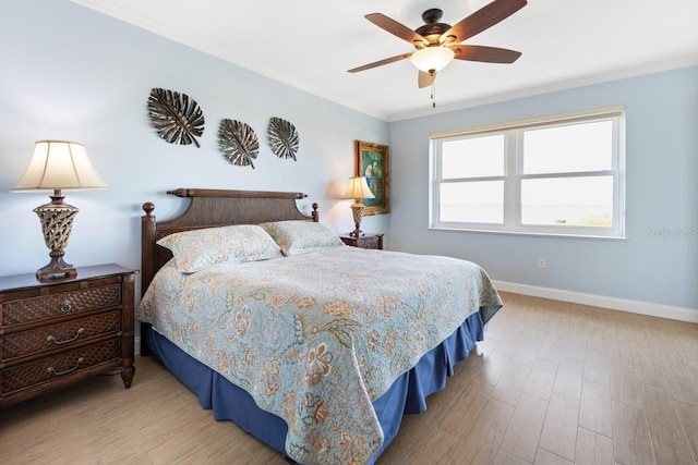 bedroom featuring ceiling fan, light hardwood / wood-style flooring, and ornamental molding