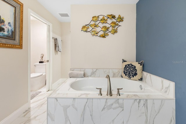 bathroom with tiled tub and toilet