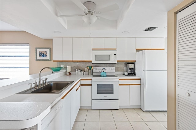 kitchen featuring kitchen peninsula, backsplash, white appliances, sink, and white cabinets