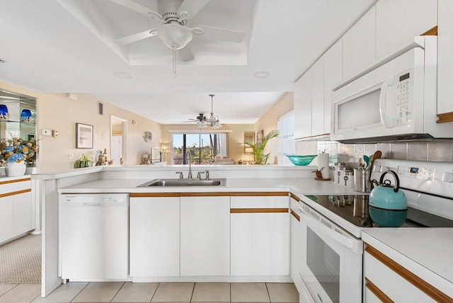 kitchen featuring white cabinetry, sink, kitchen peninsula, white appliances, and light tile patterned flooring