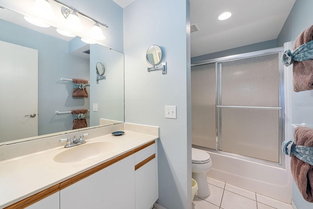 full bathroom with combined bath / shower with glass door, vanity, tile patterned flooring, and toilet