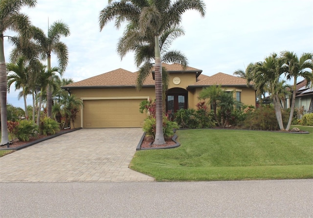 mediterranean / spanish house with a garage and a front lawn