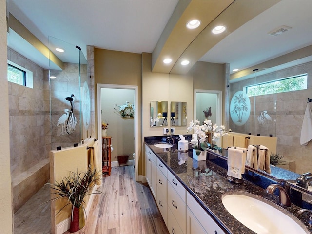 bathroom with vanity, hardwood / wood-style flooring, and tiled shower