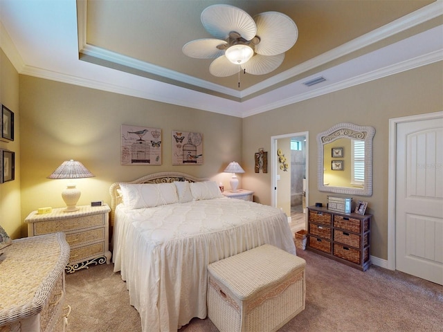 bedroom with carpet, ceiling fan, a raised ceiling, crown molding, and ensuite bath