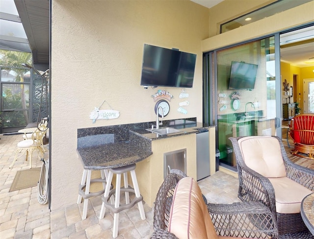 view of patio with a lanai, a wet bar, and outdoor lounge area