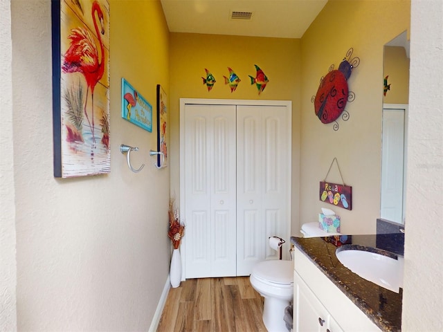 bathroom featuring vanity, toilet, and hardwood / wood-style floors