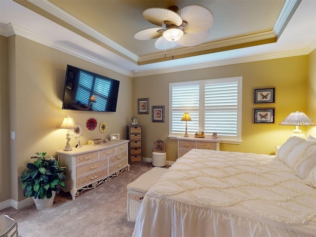 carpeted bedroom with ceiling fan, ornamental molding, and a tray ceiling