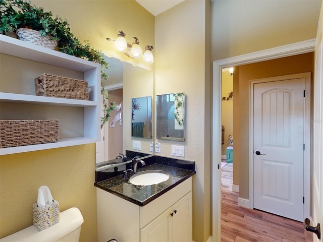 bathroom featuring vanity, hardwood / wood-style floors, and toilet