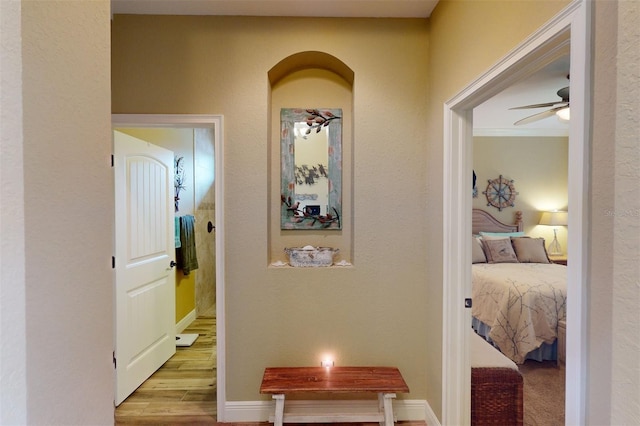 hallway featuring crown molding and light wood-type flooring