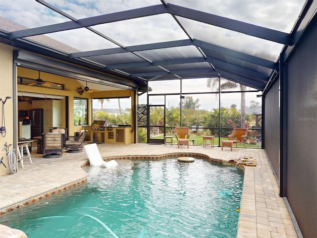 view of pool with area for grilling, a patio area, ceiling fan, and glass enclosure