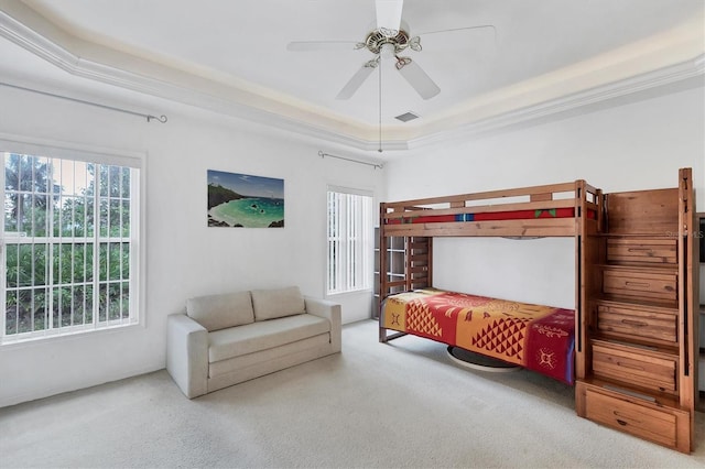 bedroom with carpet floors, a raised ceiling, ceiling fan, and ornamental molding