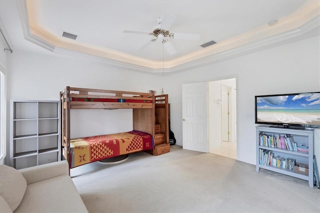 bedroom with a tray ceiling, ceiling fan, light colored carpet, and ornamental molding