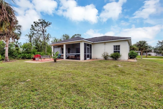 rear view of house with a sunroom and a yard