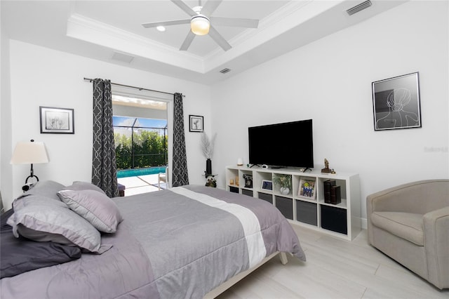 bedroom featuring ceiling fan, ornamental molding, access to outside, and a tray ceiling