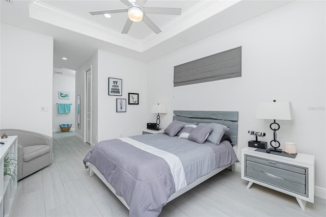 bedroom featuring a raised ceiling, ceiling fan, crown molding, and light hardwood / wood-style floors