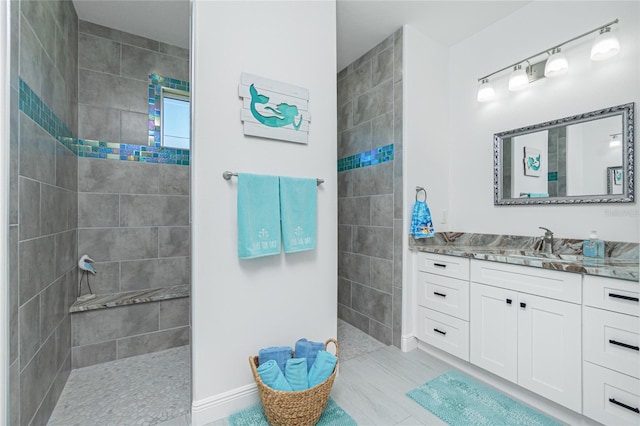 bathroom with tiled shower and vanity