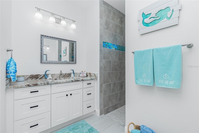 bathroom featuring tile patterned floors, vanity, and tiled shower