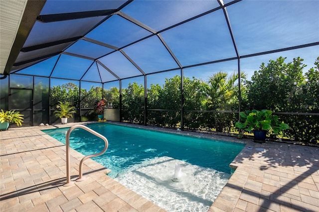 view of swimming pool featuring glass enclosure and a patio area