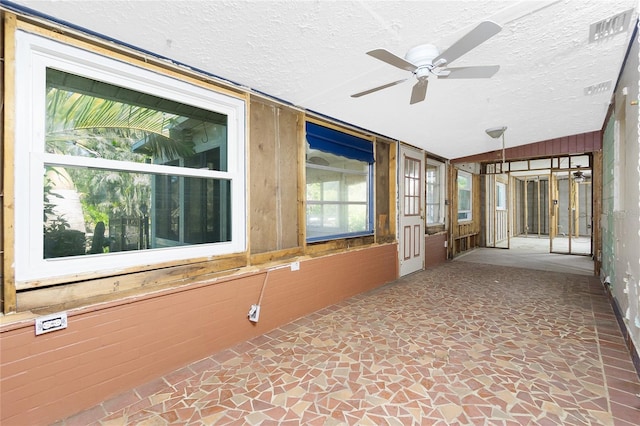 unfurnished sunroom featuring ceiling fan and lofted ceiling