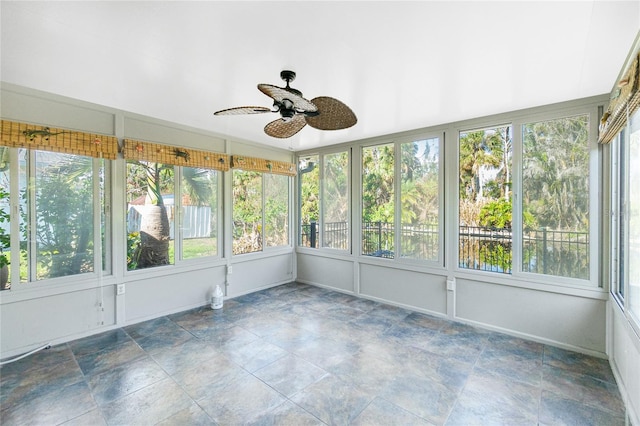 unfurnished sunroom with ceiling fan