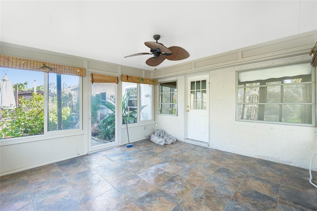 unfurnished sunroom featuring ceiling fan